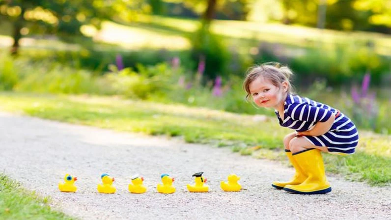 baby girl is playing with little toy docks
